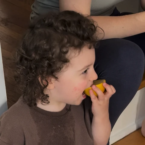 Gavi tasting a lemon and making a sour face